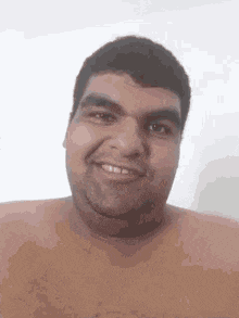 a shirtless man is smiling at the camera .