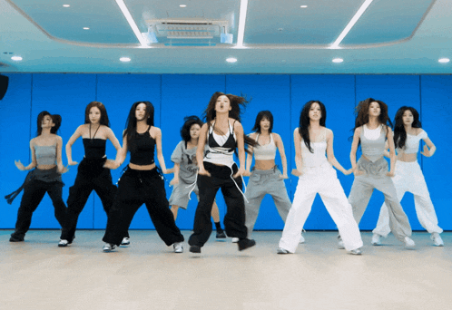 a group of women are dancing together in a room