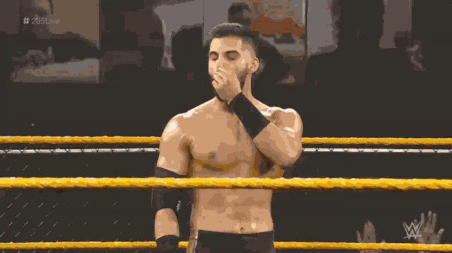 a shirtless wrestler in a wrestling ring with the hashtag # 205live in the background