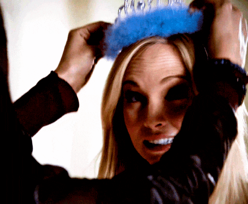 a woman wearing a blue tiara is smiling