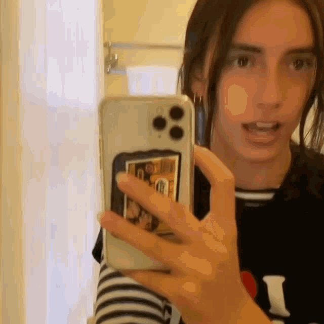 a young woman is taking a selfie with her cell phone .