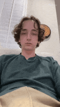 a young man is laying on a couch with his eyes closed and the word pollo ai visible in the corner