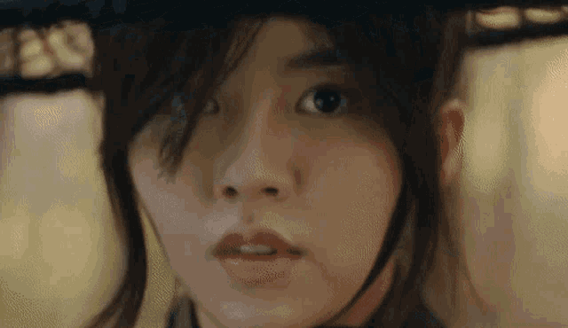 a close up of a woman 's face with a hat on