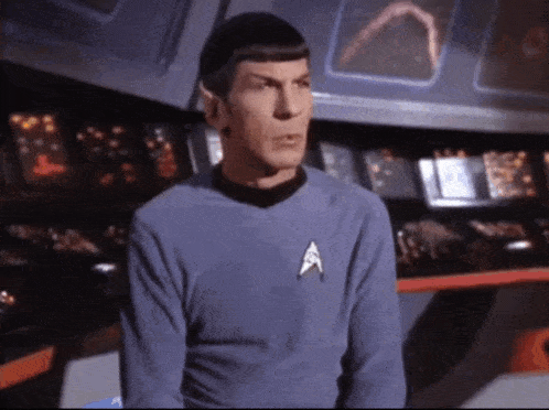 a man in a star trek uniform stands in front of a control room