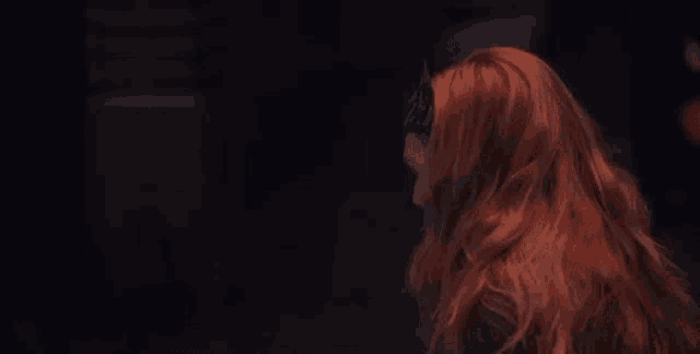 a woman with red hair and a crown on her head .