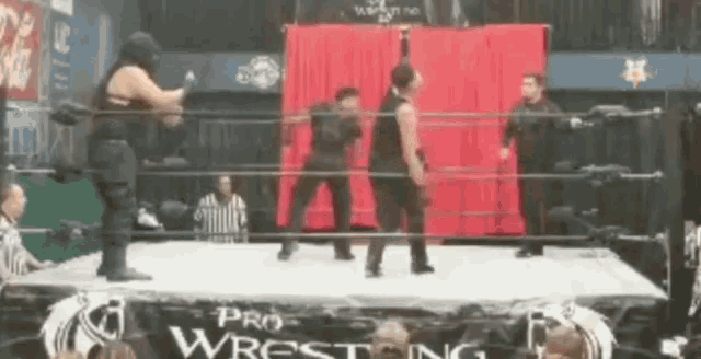 a pro wrestling ring with a red curtain behind them