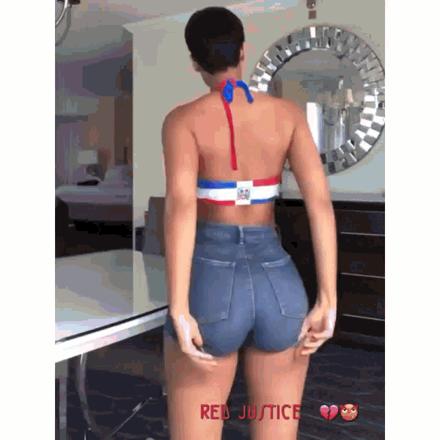 a woman in a red white and blue top and shorts is standing in front of a mirror with the words red justice on the bottom