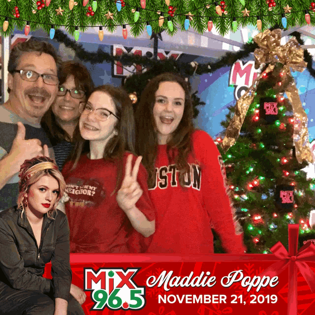 a group of people posing in front of a christmas tree with the name maddie poppe in the corner