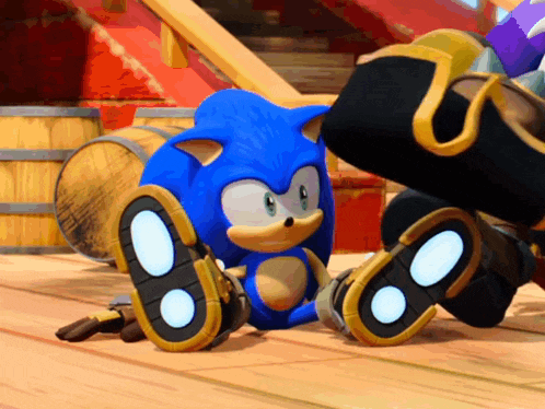 sonic the hedgehog is sitting on a wooden floor with a barrel in the background