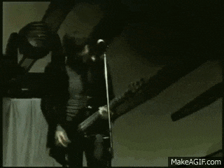 a man is playing drums on a stage in front of a fence .