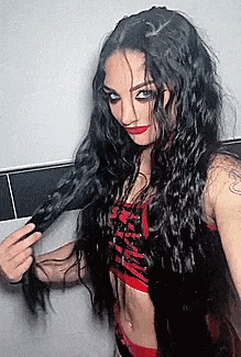 a woman with long black hair is holding a man 's hair in a braid .