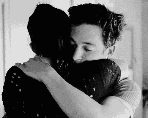 a man and a woman are hugging each other in a black and white photo
