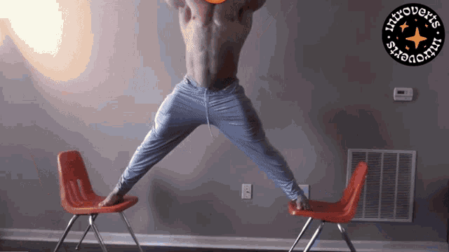 a shirtless man is jumping in the air between two red chairs with a logo for introverts on the bottom