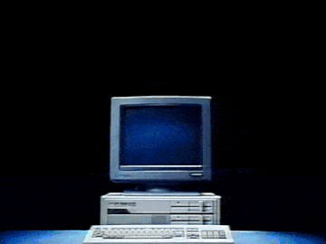 a computer is sitting in front of a wall with neon lines coming out of it