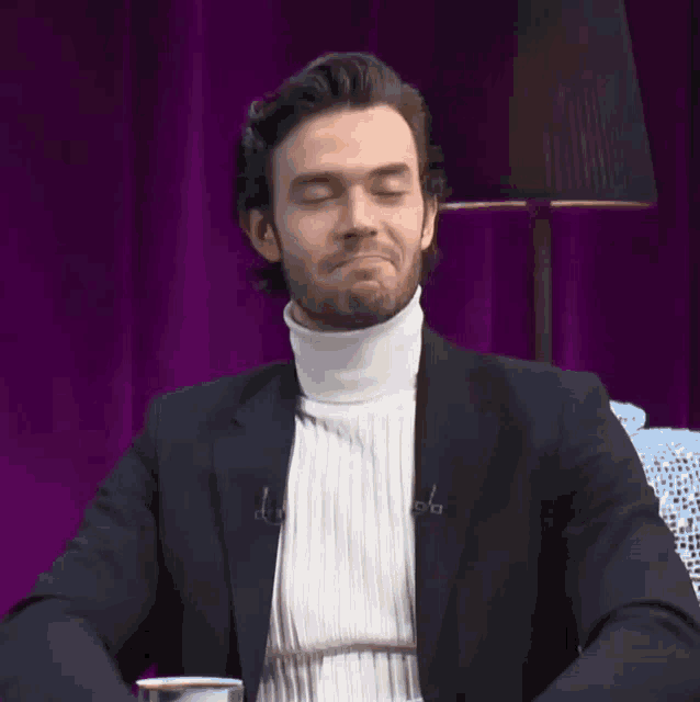 a man wearing a white turtleneck and a black jacket is making a face