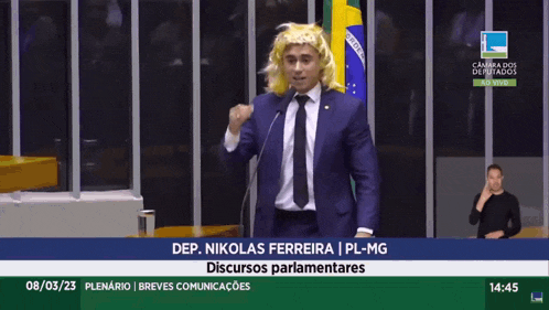 a man in a suit and tie stands in front of a microphone with the words dep. nikola ferreira on the screen