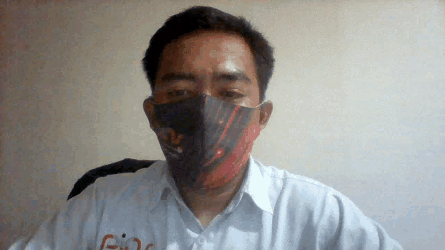 a man wearing a face mask with a red and black design