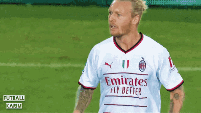 a man wearing a white emirates fly better jersey