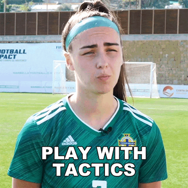 a female soccer player wearing a green adidas jersey
