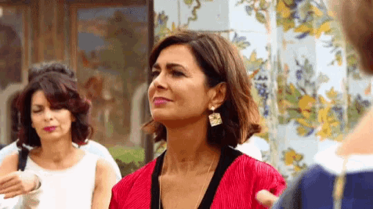 a woman in a red dress is standing in front of a tiled wall .