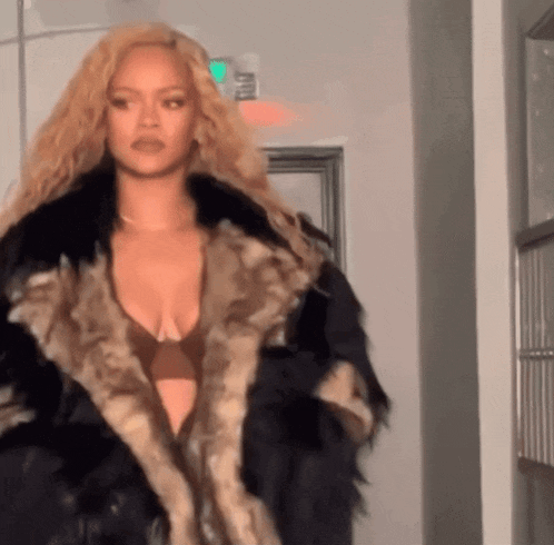 a woman with blonde hair is wearing a fur coat and bra