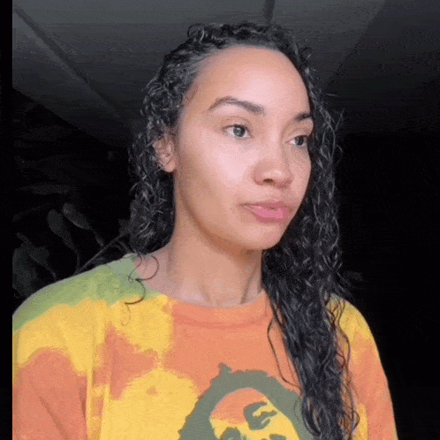 a woman with curly hair is wearing a t-shirt that says bob marley on it