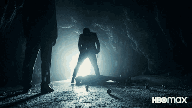 a poster for hbomax shows a man standing in a dark cave