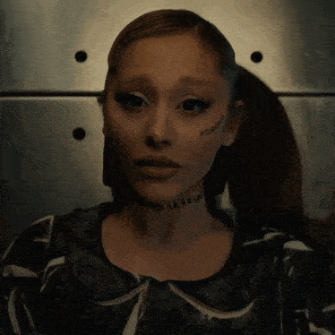 a woman with a tattoo on her face that says ariana grande