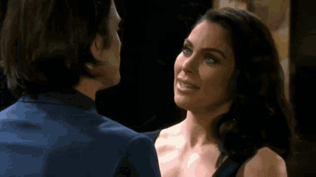 a man and a woman are kissing and the woman is wearing earrings