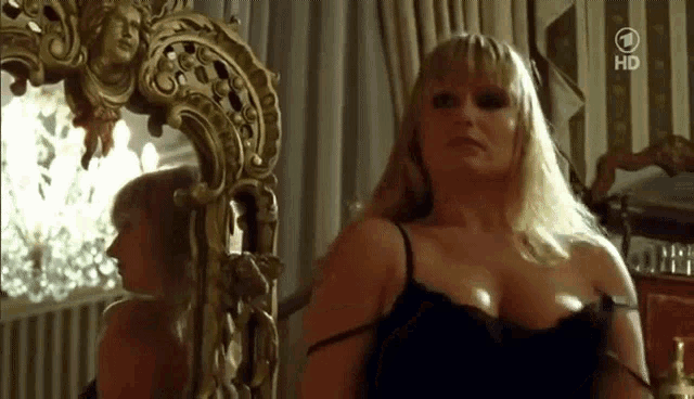 a woman is sitting in front of a mirror with the number 1 on the bottom right