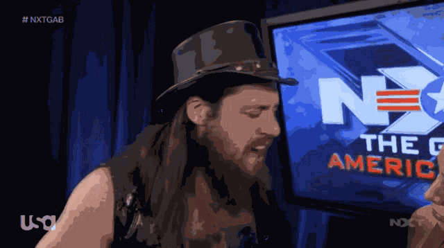 a man in a top hat stands in front of a screen that says nxtgab