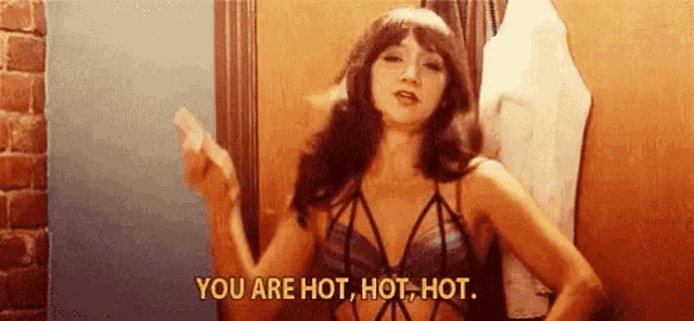 a woman in a bra is holding a condom and saying `` you are hot , hot , hot . ``