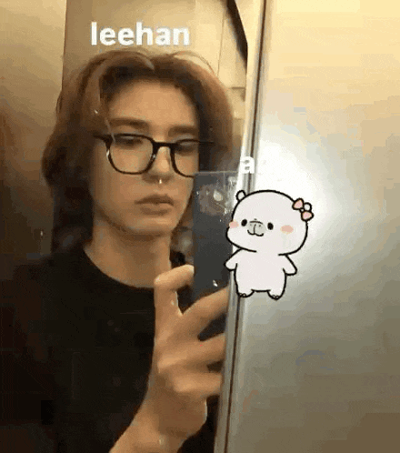 a person is taking a selfie in front of a mirror with a cartoon bear .