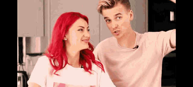a man and a woman are standing next to each other and the woman has red hair