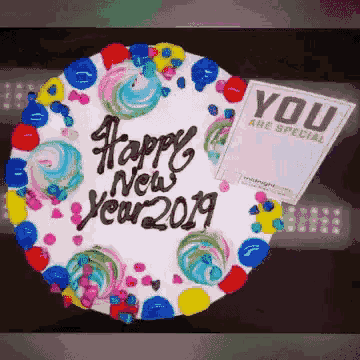 a colorful cake with the words happy new year 2019 written on it