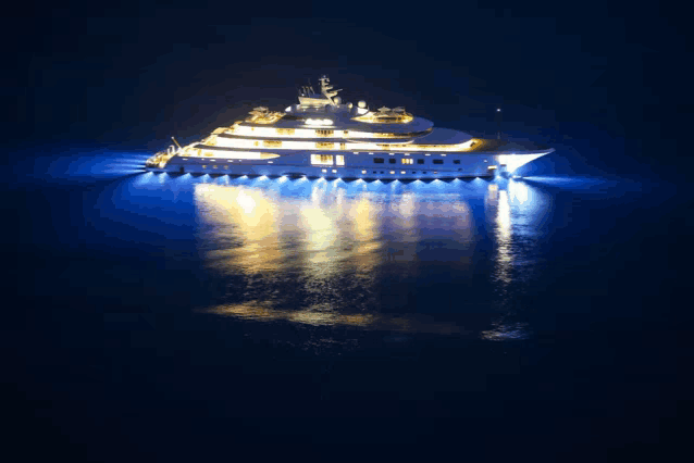 a large yacht is floating in the ocean at night