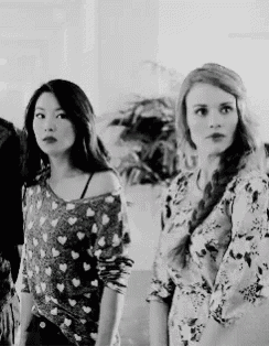 three women are standing next to each other in a room .