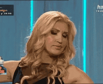 a blonde woman in a black dress is standing in front of a sign that says hay