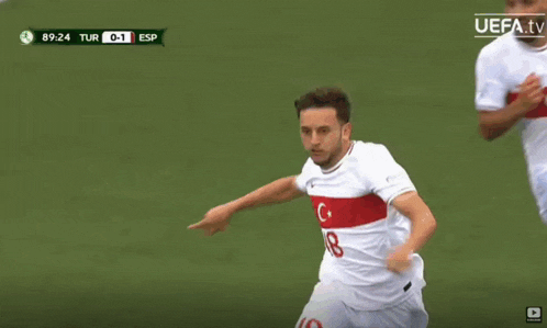 two soccer players running on a field with a uefa tv logo in the corner