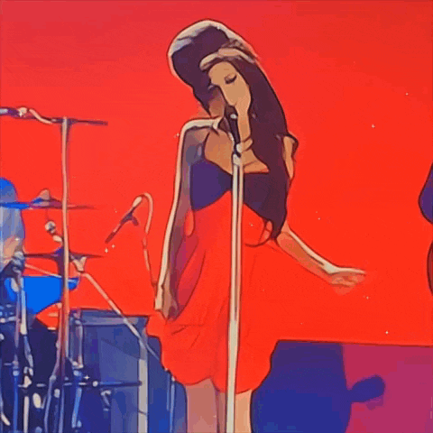 a woman in a red dress singing into a microphone on a stage