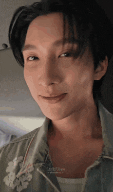 a close up of a young man 's face with a smile on his face