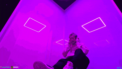 a person is taking a picture in a room with blue lights and a watermark that says badge