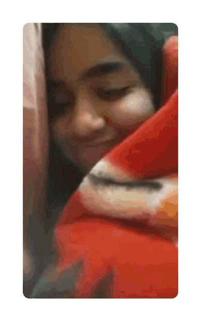 a woman is wrapped in a red blanket and smiling with her eyes closed