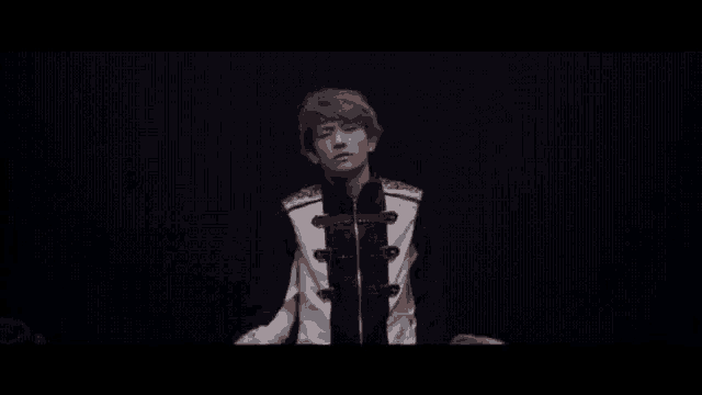 a man in a black and white uniform is standing in the dark