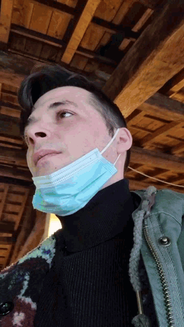 a man wearing a face mask looks up at the sky