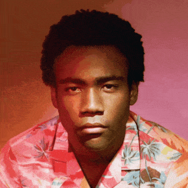 a man wearing a hawaiian shirt is looking at the camera