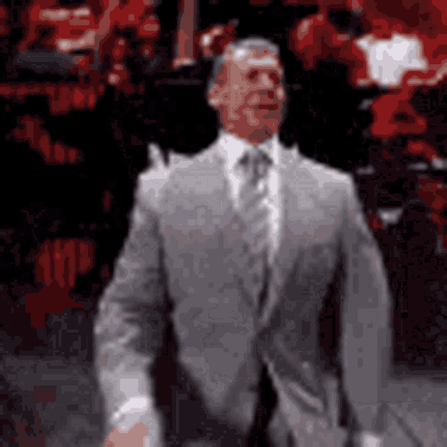 a man in a suit and tie is standing in front of a crowd of people .