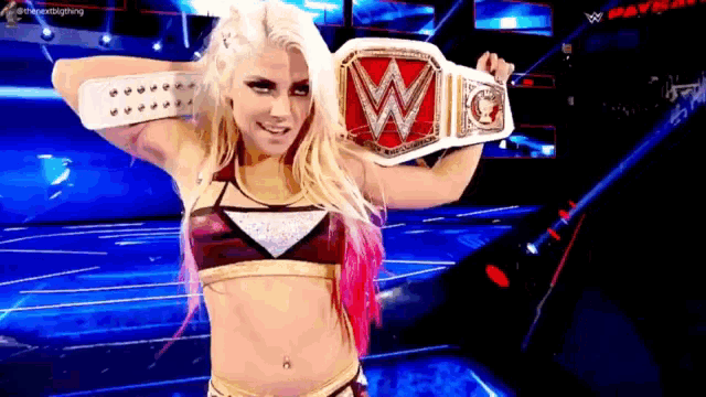 a woman in a wrestling outfit is holding a wrestling belt with the letter w on it