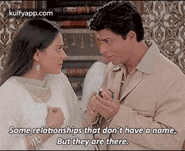 a man and a woman are standing next to each other and talking to each other .