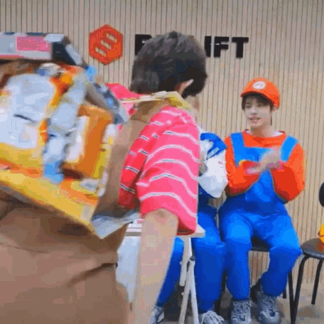 a man in a mario costume holds a bag of chips